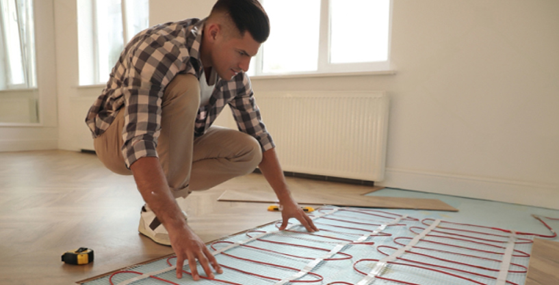 Young man installing radiant heat mats